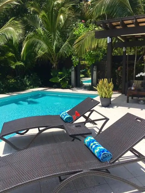 Photo of stunning pool with lounge chairs and lush garden at an Airbnb in Miami.