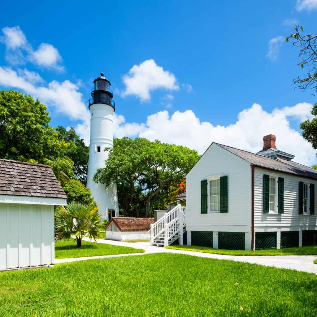 View of the Key West Lighthouse and Keeper's Quarters Museum sitting on a green lawn.