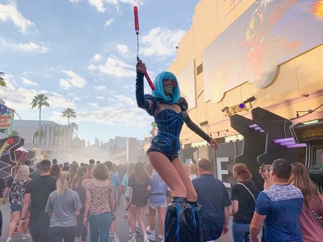 A stilt walker menacingly swings red nunchucks at patrons as they arrive at Halloween Horror Nights at Universal Studios Orlando, one of the spookiest ways to celebrate Halloween in Florida. 