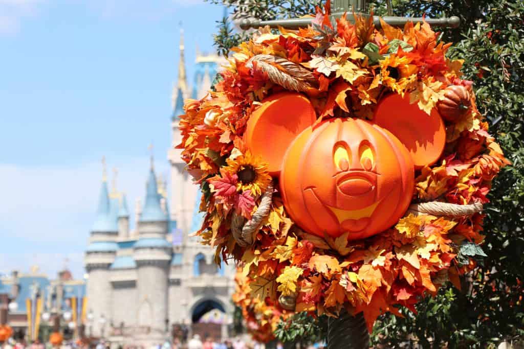 A smiling pumpkin Mickey Mouse laid in an autumn wreath greets guests on their way to Cinderella's Castle at Mickey's Not-So-Scary Halloween Party, the ultimate way to celebrate Halloween in Florida.