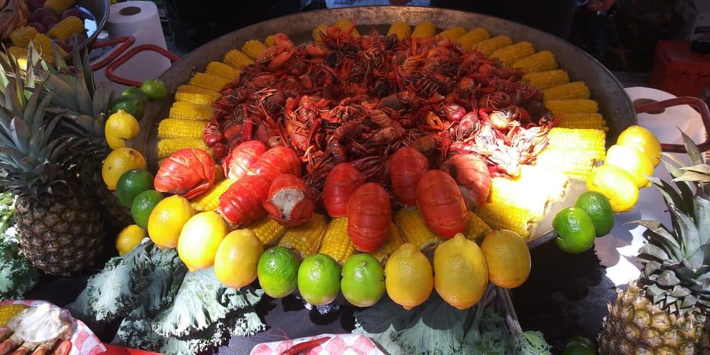 A gigantic platter of seafood and shellfish surrounded by corn on the cob awaits the visitors of the Pensacola Seafood Festival, a perfect way to enjoy Florida in fall.