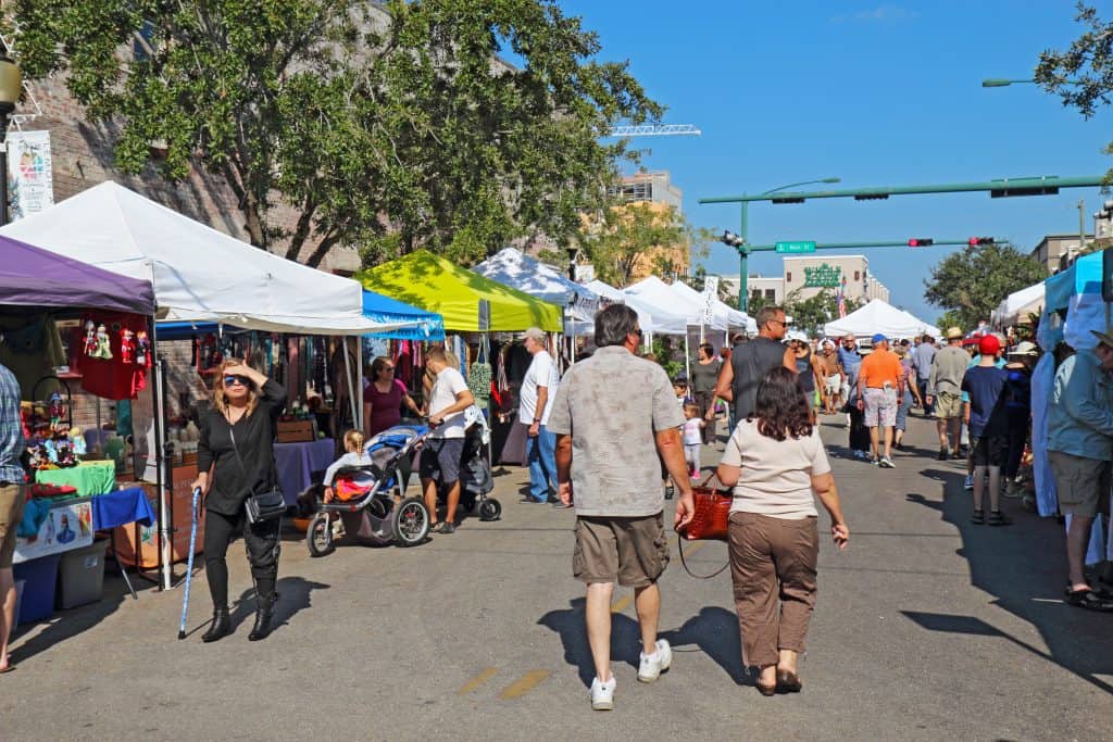 Pedestrians walk through the streets of downtown at the Sarasota Farmers Market, a highlight of Florida in fall.