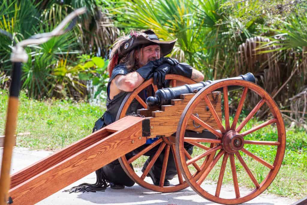 A swashbuckler perches on his cannon at the Florida Renaissance Festival.