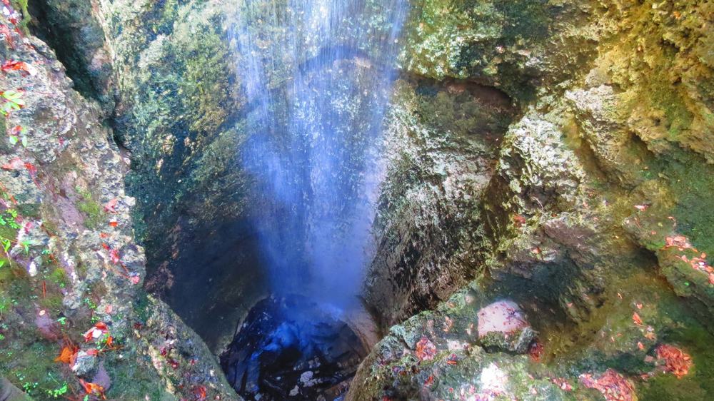 Blue water cascading down to the bottom of a sinkhole known as Falling Waters, one of the prettiest natural waterfalls in Florida. 