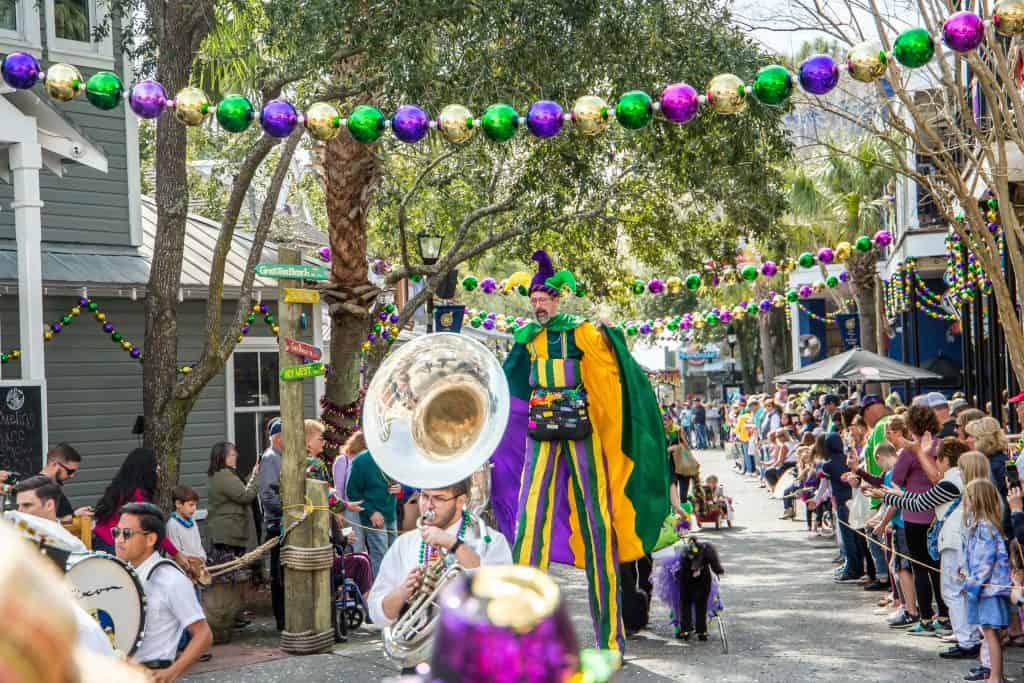 The Mardi Gras Parade with a band and people in costumes takes over downtown Destin.