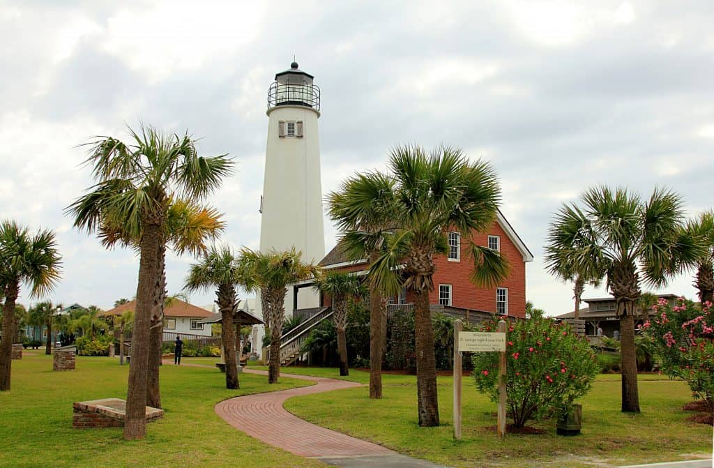 A brick walkway lined with palm trees leads to the brick lighthouse and light tower on Saint George Island. 