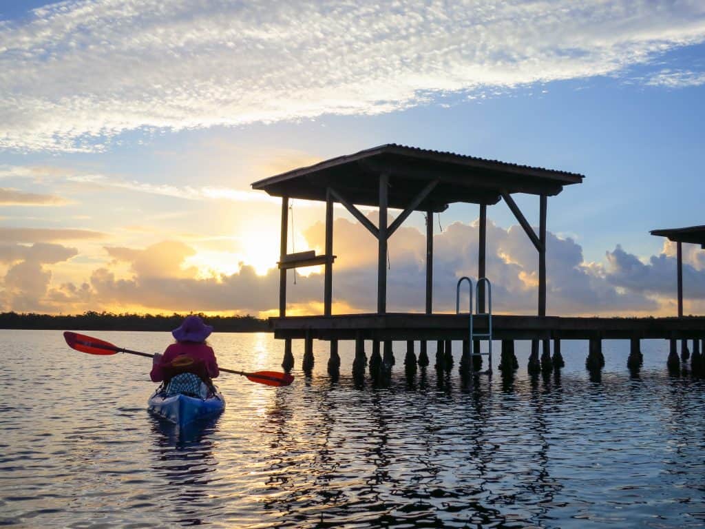 A kayaker paddles on the Wilderness Waterway and enjoys the sunset, one of the best Everglades attractions. 