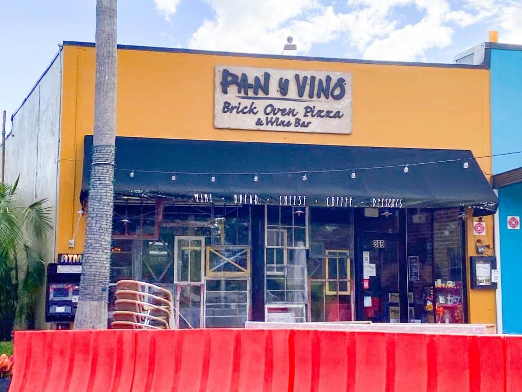 The mustard yellow exterior of Pan Y Vino, a combination pizzeria and wine bar.