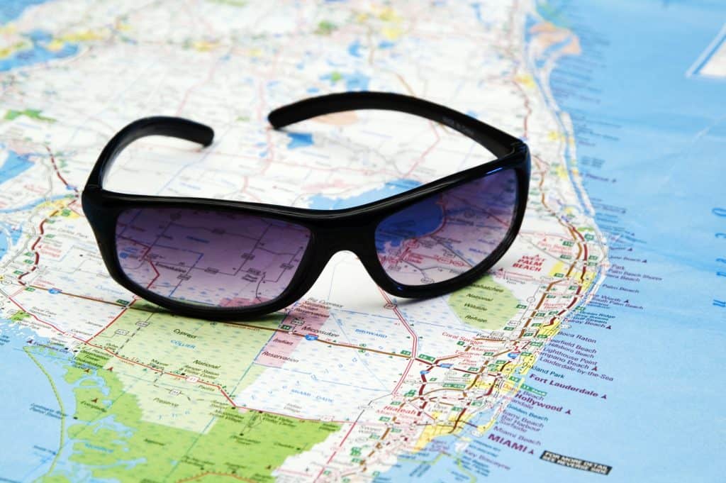A pair of sunglasses sits on top of a map of Florida, ready for you to hit the open road. 