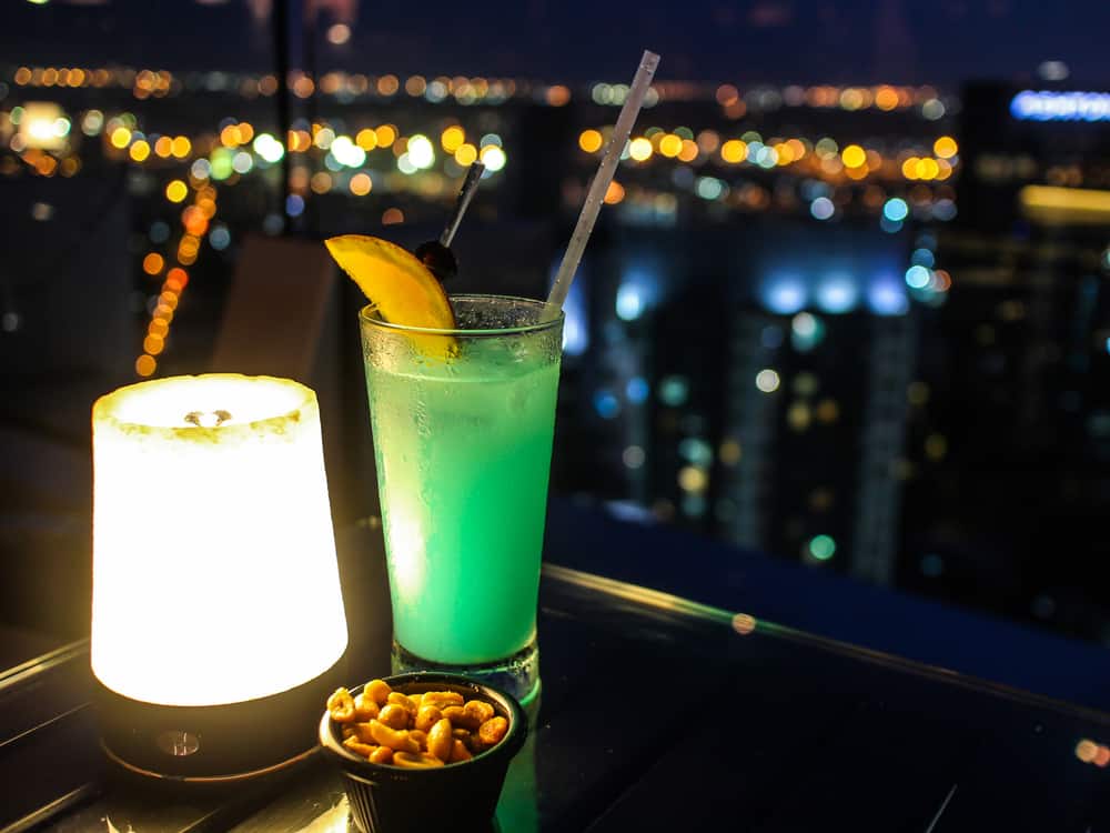 Two drinks with the night sky in the background in an article about rooftop bars in Orlando