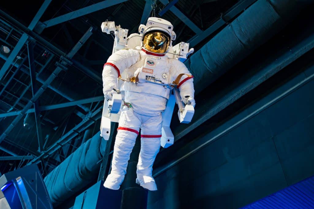 A space suit hangs over the crowds as they pass through the exhibits of the Kennedy Space Center.