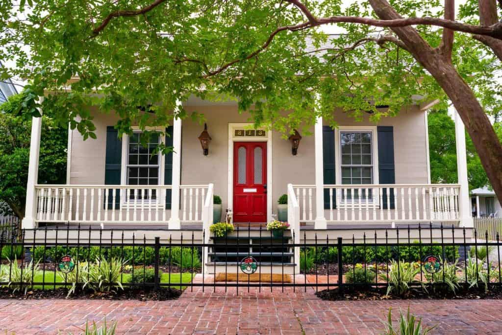 Photo of the exterior of an 1850s Historic Cottage Airbnb in Florida with a bright red door.