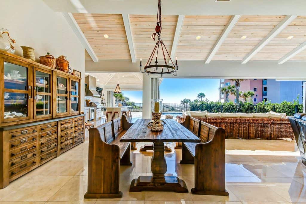 Photo of the dining table, cabana, and outdoor dining inside a resort-style luxury home Airbnb. 