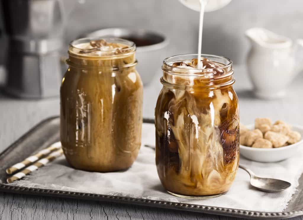 Milk is poured over cold brew in a mason jar mug!