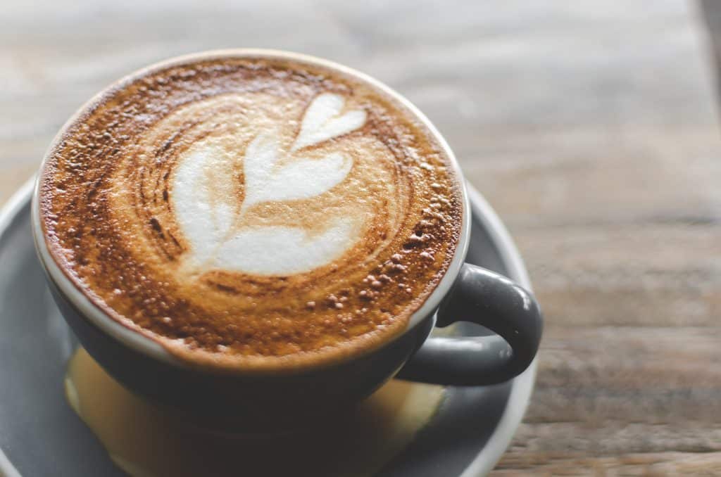 An espresso machiatto is served with a heart design, made with the best coffee in Miami.