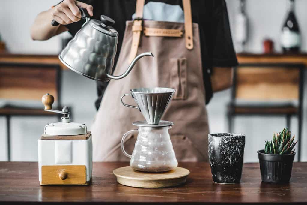 A barista pours hot water over a chemex, a brewing method to produce the best coffee in Miami.