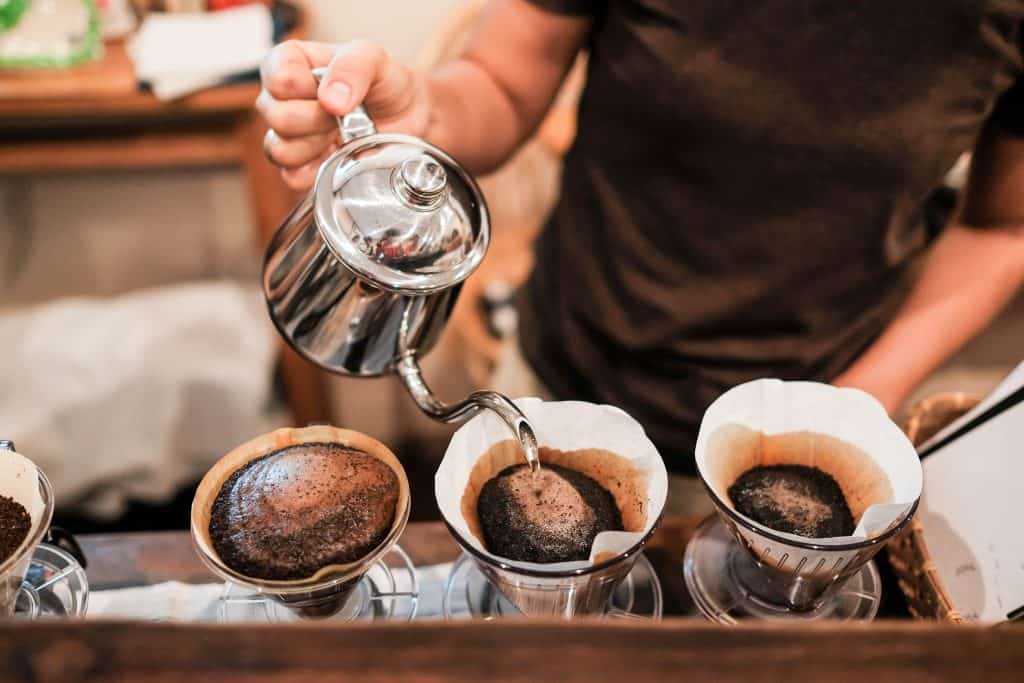A barista pours hot water in the pour over method of brewing, producing the best coffee in Miami. 