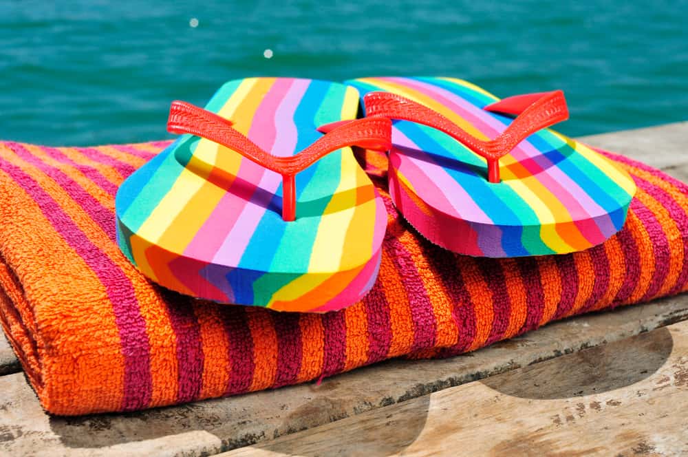 Rainbow flip flops on a towel in an article about gay beaches in Florida