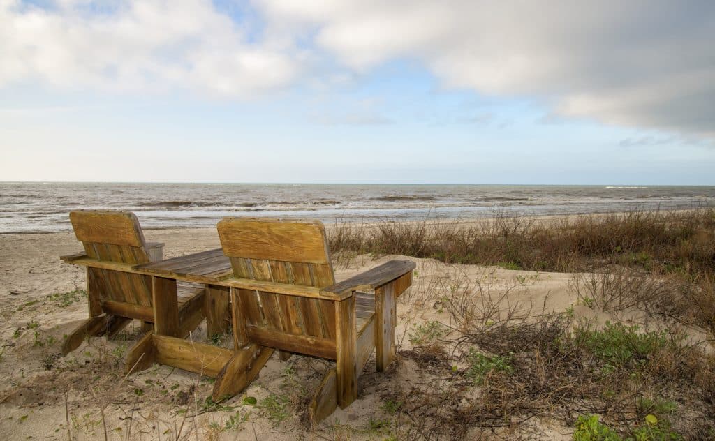 Two chairs sit in the sea landscape of Apalachicola, one of the best small towns in Florida.