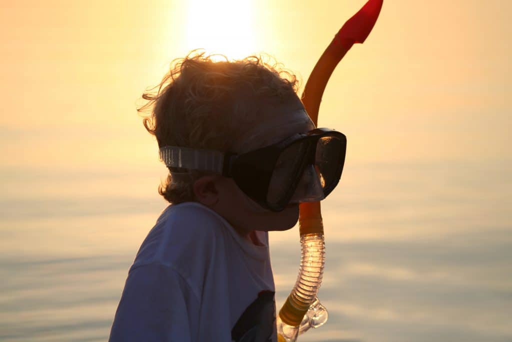 A child dons a snorkel and mask in the sunset of the Florida Keys.