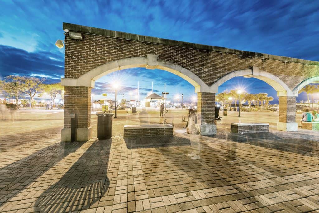 The arches of Mallory Square, one of the best things to do in the Keys, glimmer in the night lights.