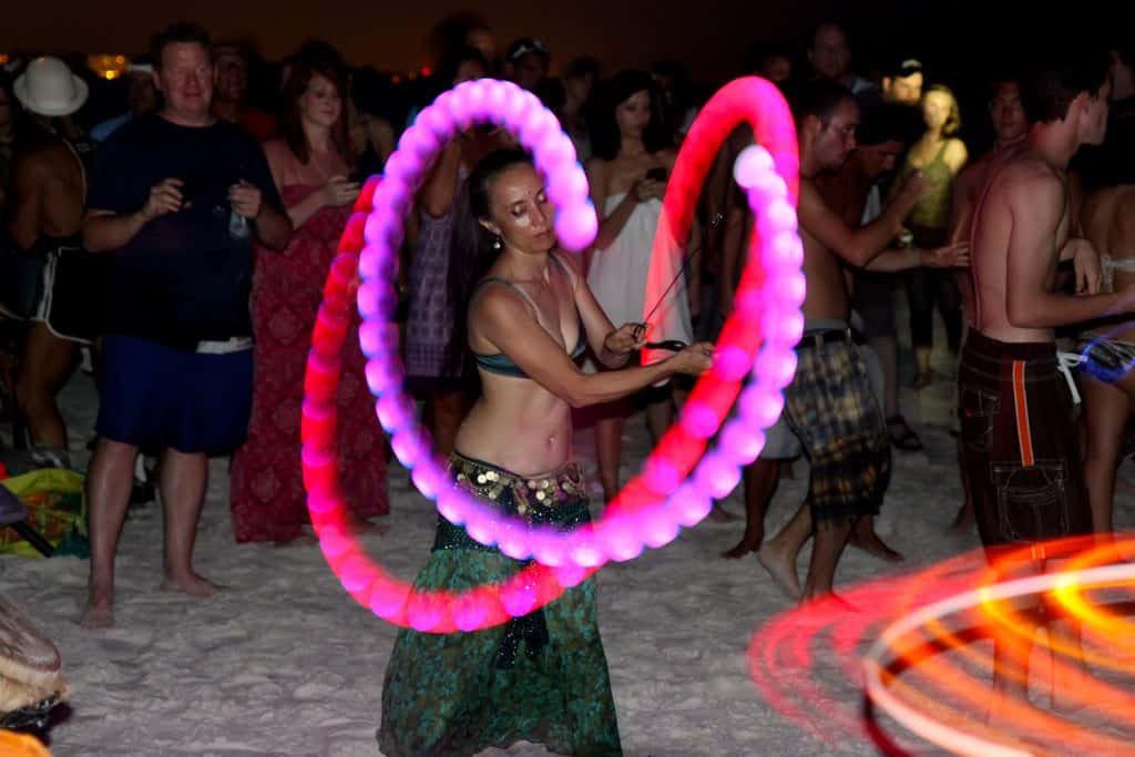 A dancer twirls lights while belly dancing during the Siesta Key Drum Circle.