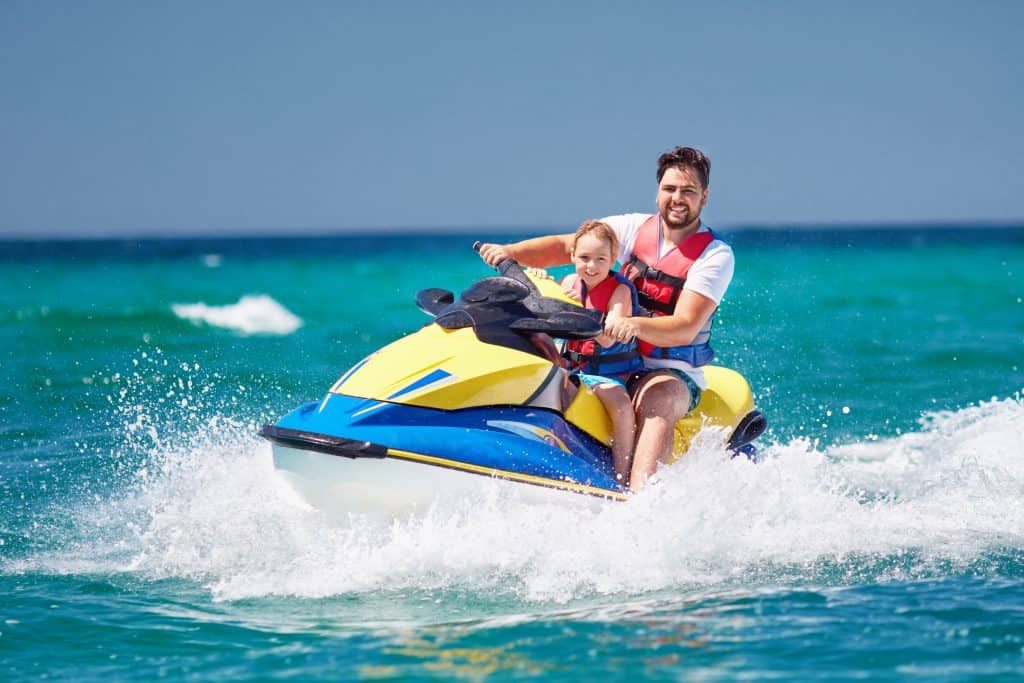 Tourists enjoy riding a jet ski on the waves, courtesy of Siesta Key Watersports.