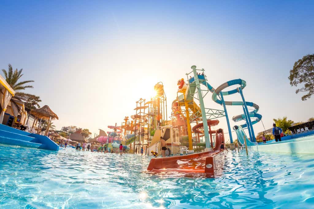 An abundance of waterslides overlooking a swimming pool on the verge of sunset