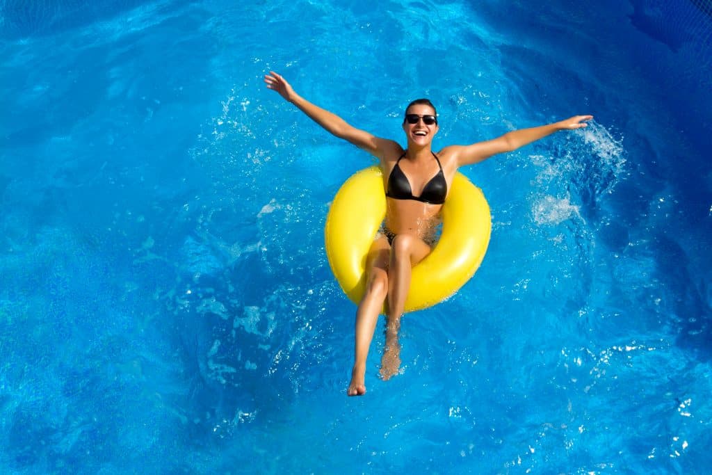A woman in a yellow tube floating in a pool