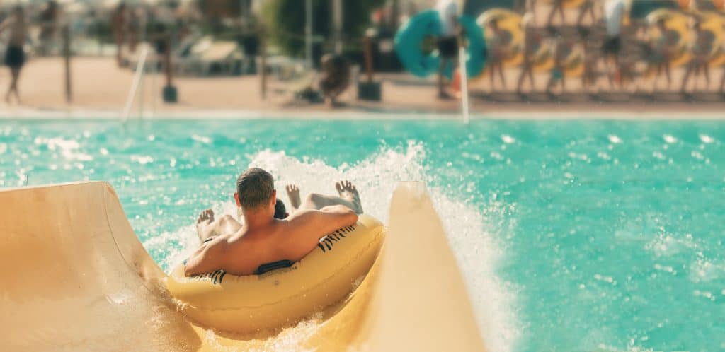 A man in a yellow tube going down a waterslide