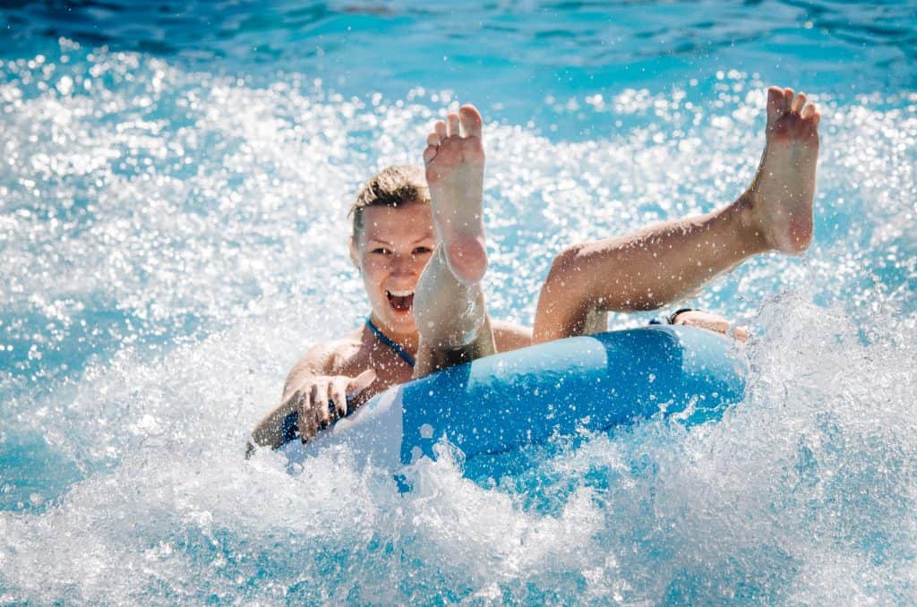 A woman in a blue tube caught in a wave