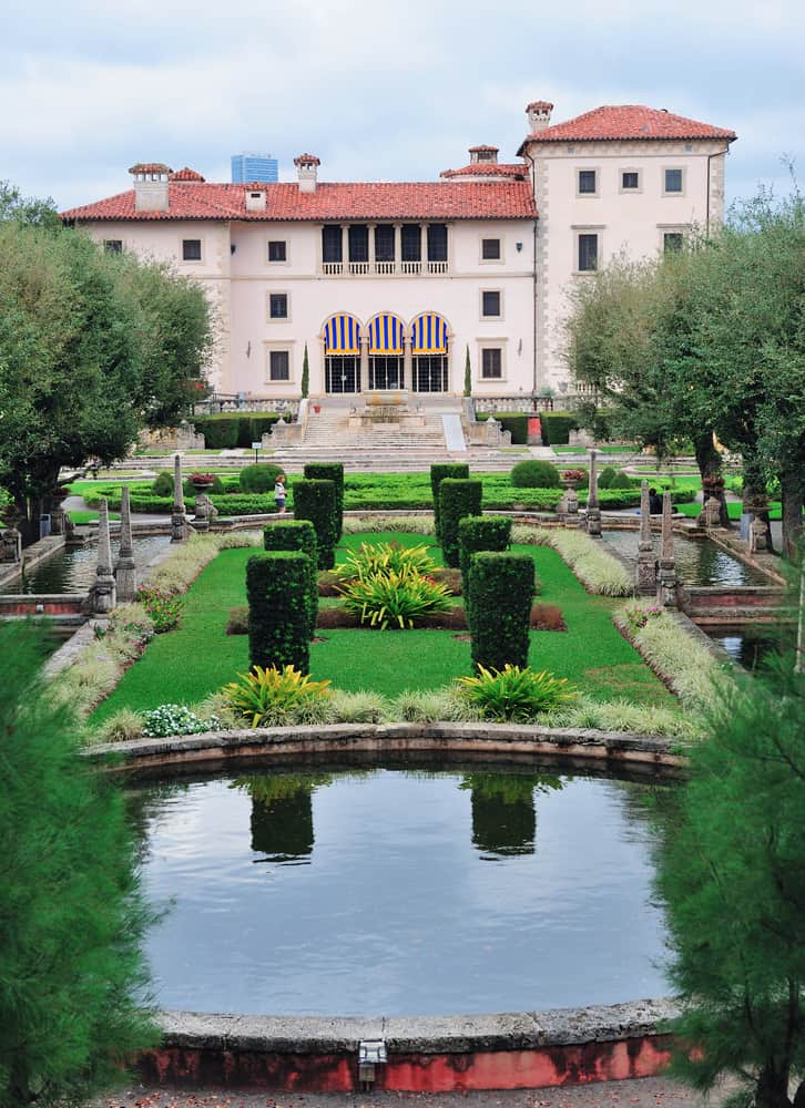 The European Gardens at vizcaya complete with reflecting ponds and statues with the home in the background