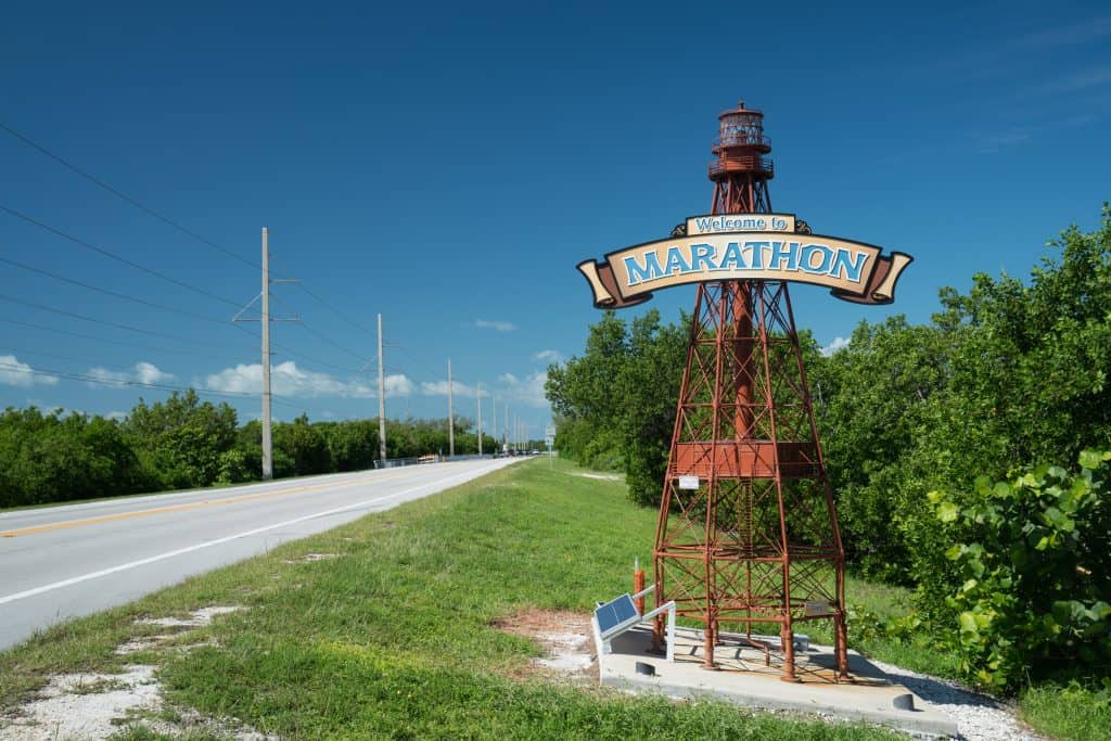 A sign shaped like a lighthouse welcomes guests to Marathon.
