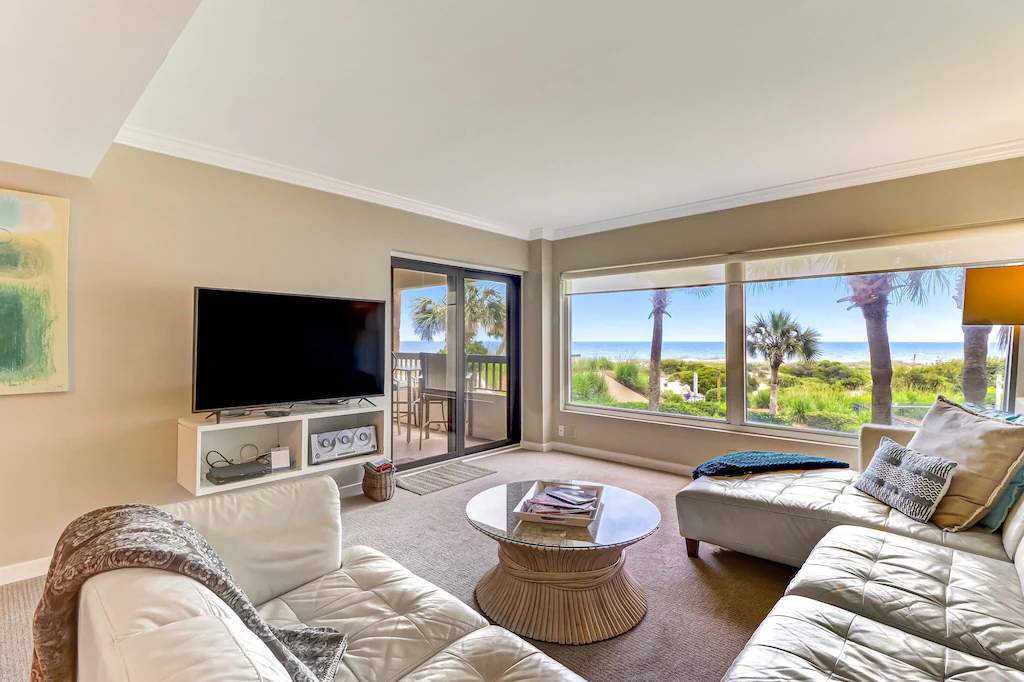 An open and spacious living area in the Charming Oceanfront One Bedroom Condo provides stunning views of the Atlantic Ocean