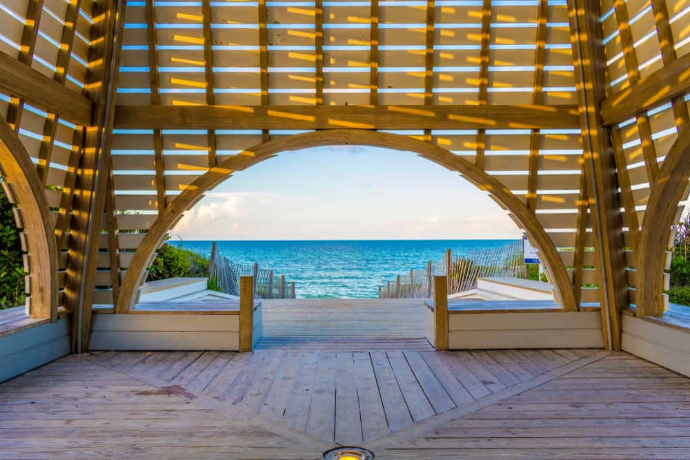 The interior of a wooden beach pavilion with a path leading to the ocean in Seaside, Florida.