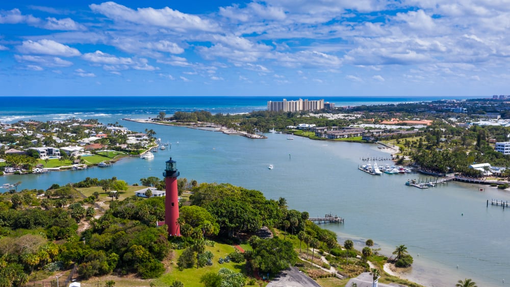 The beautiful city of Jupiter with the red lighthouse in the foreground, along with the intercostal leading out to the ocean