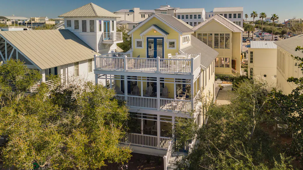 A beautiful yellow four stories home with three large balconies one of the Seaside Florida rentals.