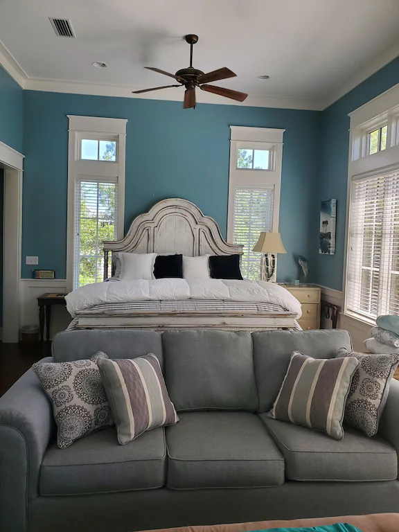 A beautiful white antique bed in a blue bedroom