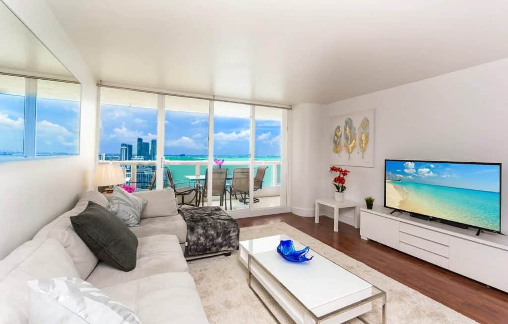 Photo of ocean view balcony and living room inside a condominium Airbnb in Miami.