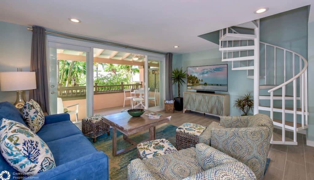 Naturally lit VRBO with a beachy theme and a spiral staircase