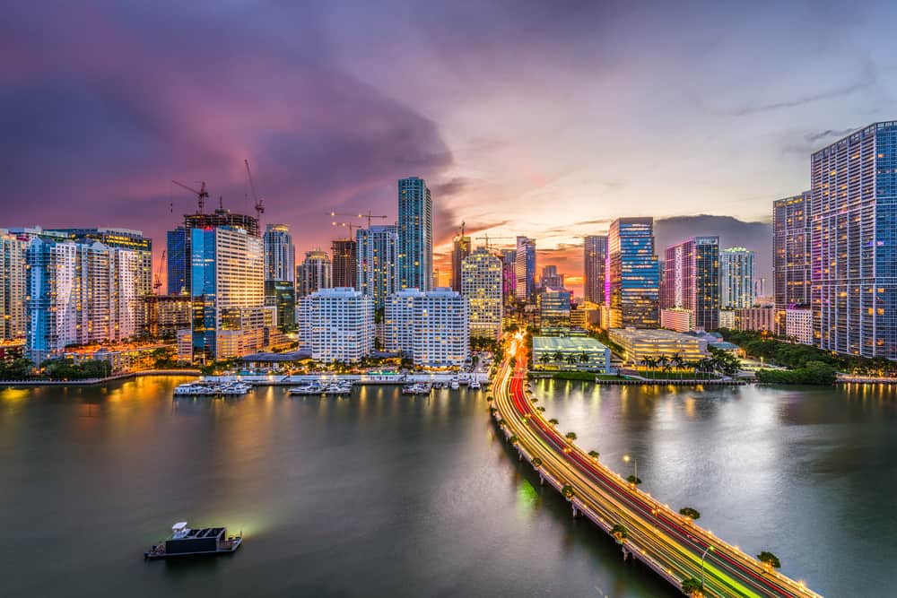 Aerial shot looking over the water towards downtown Miami at dusk.