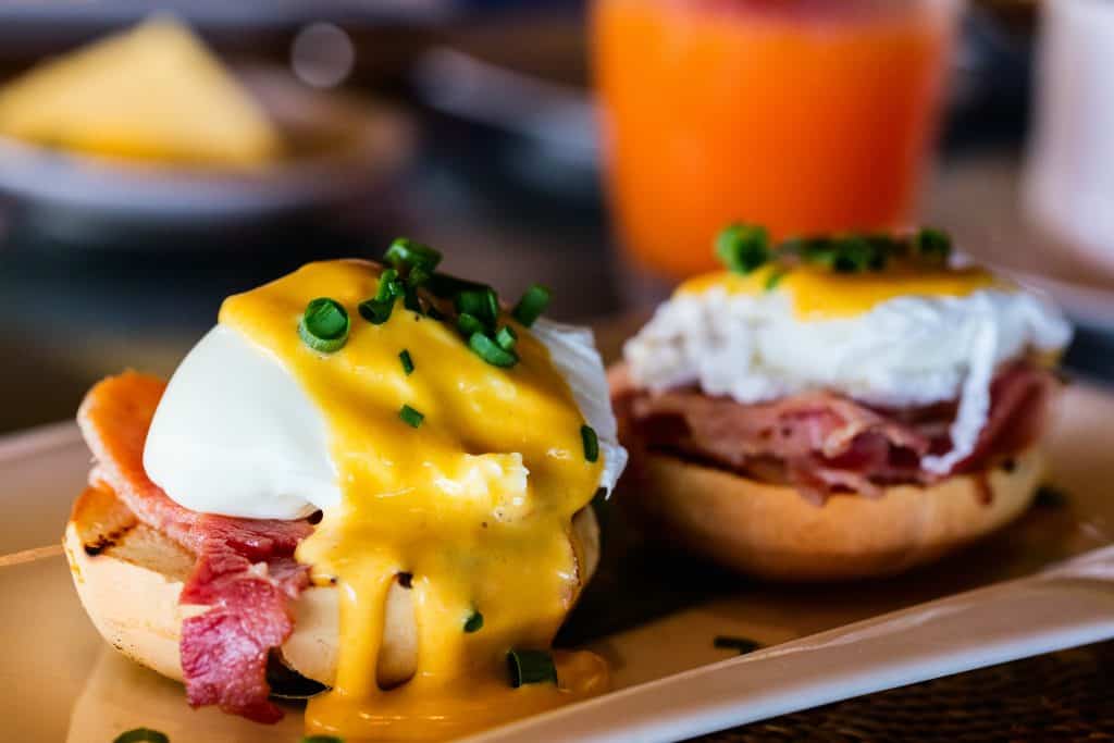 Two eggs benedict with hollandaise sauce.
