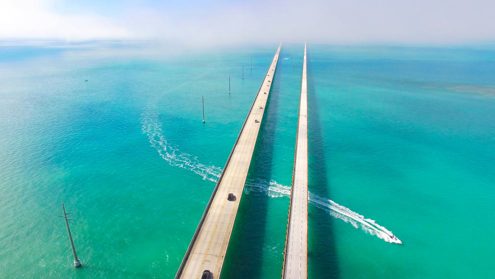 Aerial view of two roads crossing over a large swath of turquoise ocean on the Miami to Key West Drive.