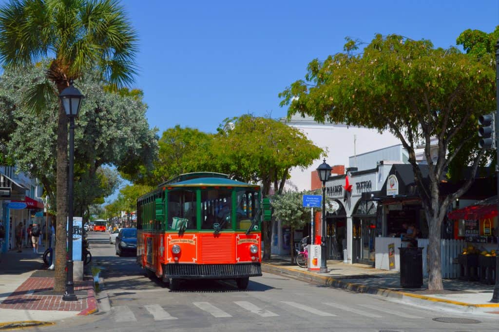 Trolley driving downtown among shops.