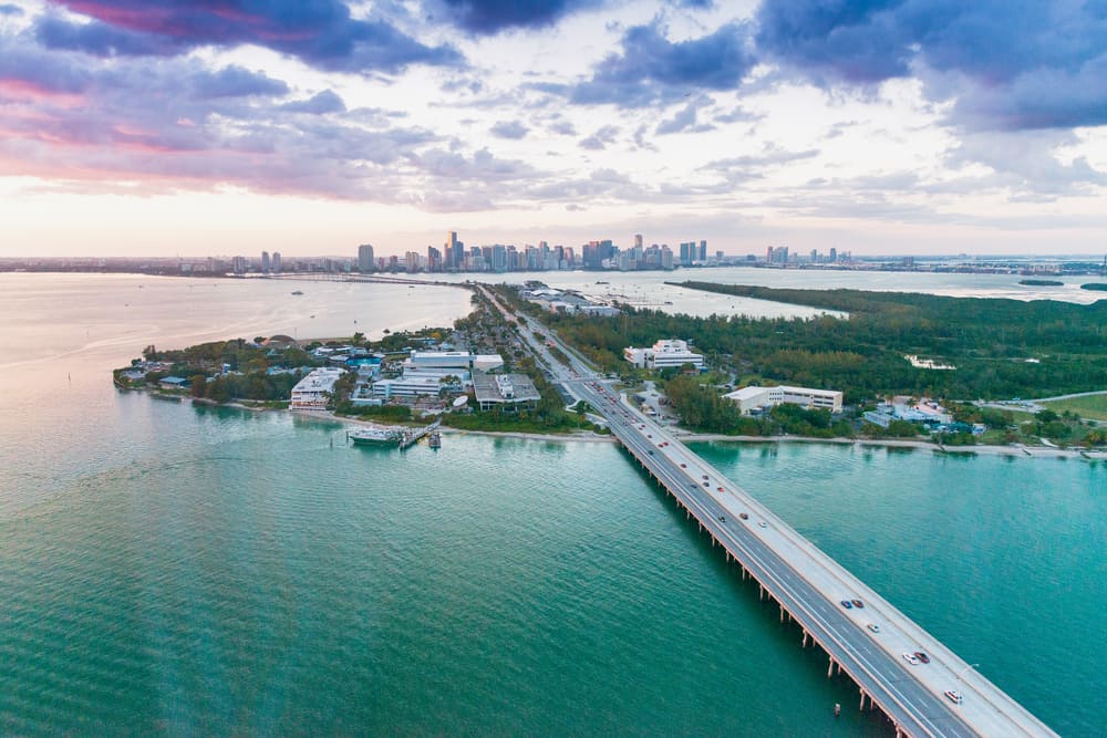 An aerial view of a highway crossing from Miami over water to the greenery of Key Biscayne, which is a popular spot for weekend getaways from Miami.