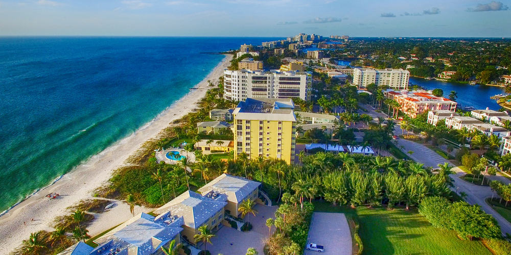 Naples coastline with emerald water on one side and colorful buildings on the other, where one can stay on weekend getaways in Florida.