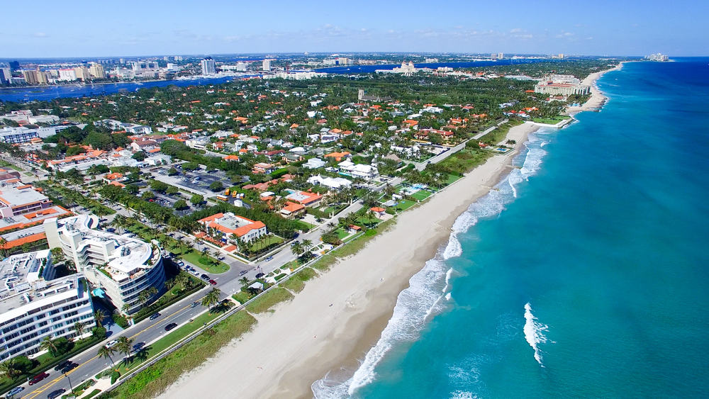 Aerial view of the sandy Palm Beach coastline, with terra cotta-colored rooftops on a sunny day, one of the popular weekend getaways in Florida.