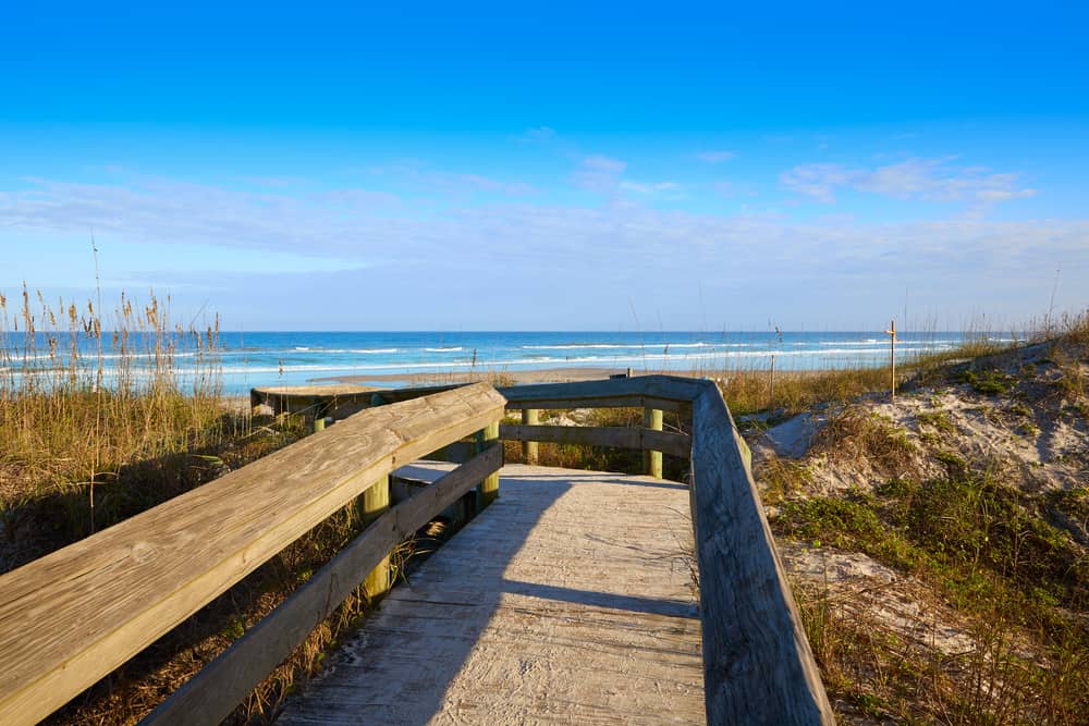 The boardwalk to enter Atlantic beach in Jacksonville Florida curves through the sand and onto the miles of beach. It is one of the best things to do in Jacksonville because it is so iconic.