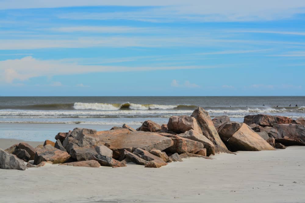 The beach at Huguenot Memorial park is one of the best things to do in Jacksonville with its large rocks and driving beaches and blue skies! 