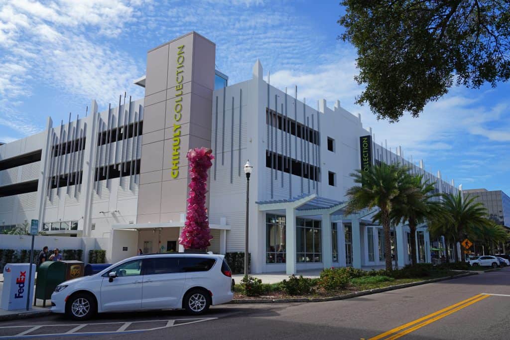 The palm tree-lined entrance of the Chihuly Museum with a glass sculpture out front, one of the best things to do in St. Petersburg Florida.